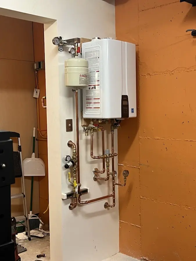 Plumbing technician inspecting water heater connections in Westport